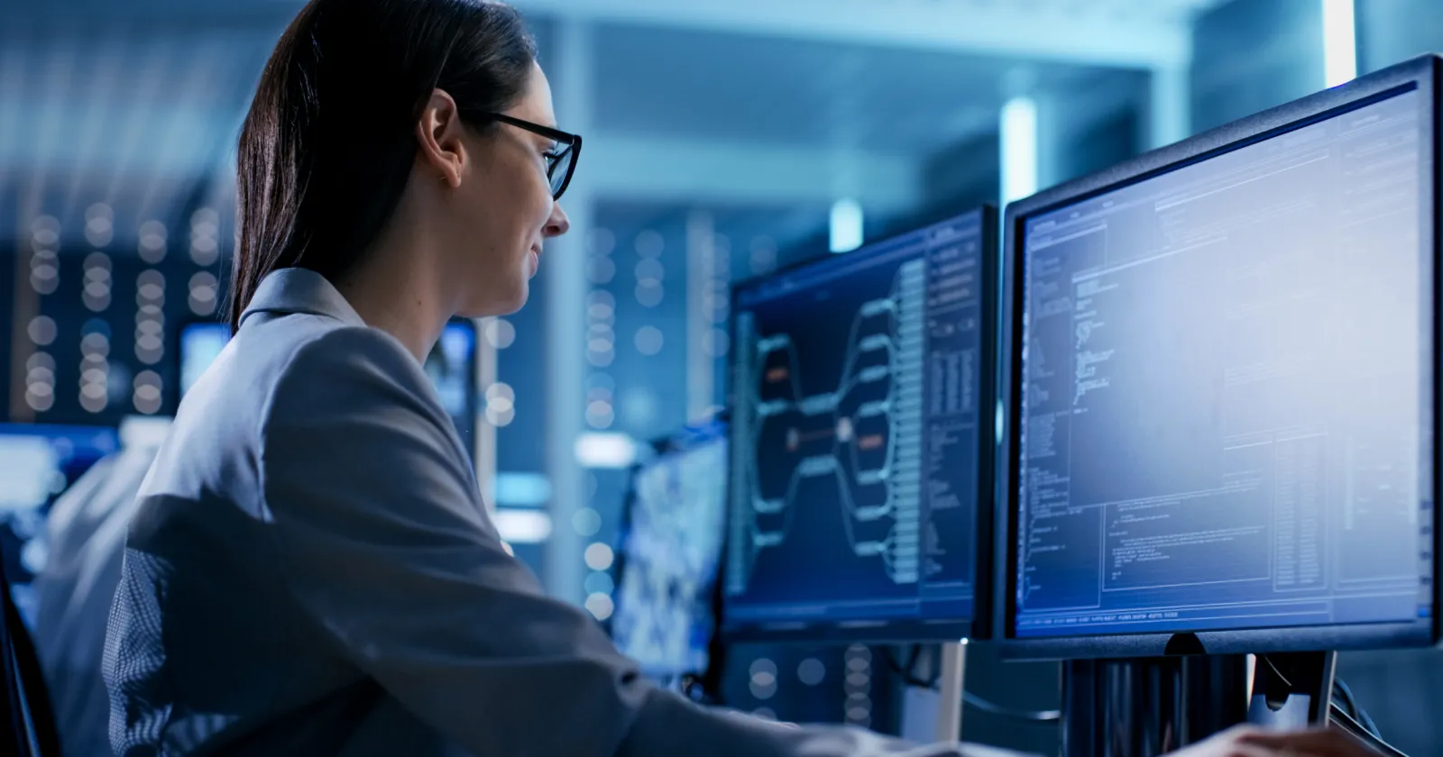  Close-up Shot of Female IT Engineer Working in Monitoring Room. She Works with Multiple Displays.