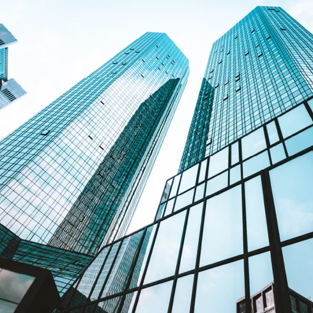 Close up view of glass building sky rise with blue sky above 